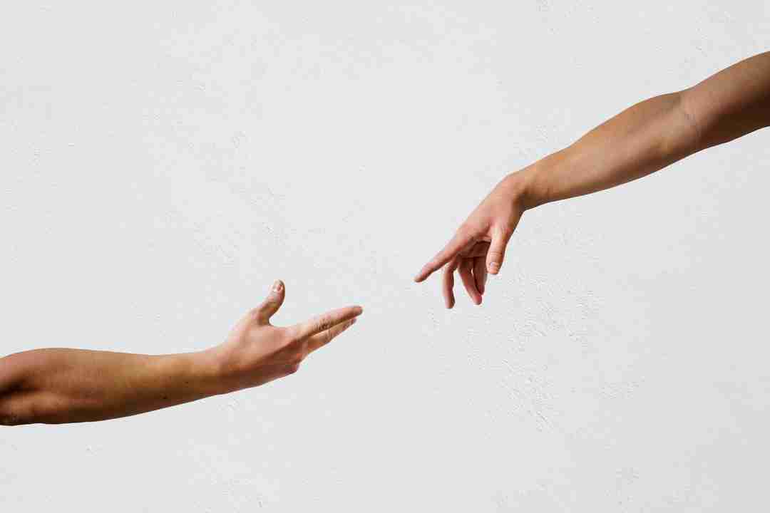 Two hands reaching towards each other in a therapeutic manner